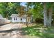 Exterior view showing a well-maintained home with a bright yellow front door, lush trees, and a landscaped yard at 2804 Barmettler St, Raleigh, NC 27607