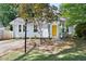 Charming single-story home featuring a bright yellow door, a brick pathway, and a well-manicured front yard at 2804 Barmettler St, Raleigh, NC 27607