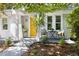 Inviting front porch with a bright yellow door, black chairs, and a small table creates an ideal space for relaxing at 2804 Barmettler St, Raleigh, NC 27607