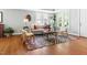 Inviting living room featuring hardwood floors, neutral sofa, stylish rug, and plenty of natural light from the windows at 2804 Barmettler St, Raleigh, NC 27607