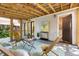 Relaxing screened-in porch featuring wooden beams, comfortable seating, and access to the yard at 2804 Barmettler St, Raleigh, NC 27607