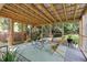 Relaxing screened-in porch featuring wooden beams, comfortable seating, and a green view of the yard at 2804 Barmettler St, Raleigh, NC 27607