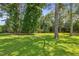 Lush backyard featuring mature trees and a well-maintained lawn at 3109 Gold Dust Ln, Willow Springs, NC 27592