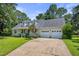 Traditional ranch home with dormer windows and attached two-car garage, surrounded by mature trees and a well-maintained lawn at 3109 Gold Dust Ln, Willow Springs, NC 27592
