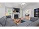 Cozy living room featuring a fireplace, gray sofa, and adjacent dining area at 3109 Gold Dust Ln, Willow Springs, NC 27592
