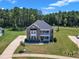 Aerial view of a charming brick home with lush landscaping, a spacious yard, and a welcoming driveway at 326 S Parliament Way, Clayton, NC 27520