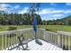 Cozy back deck overlooking a serene backyard with an umbrella, chair, and beautiful wooded views at 326 S Parliament Way, Clayton, NC 27520