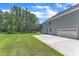 Spacious backyard with lush green grass and a concrete patio with a garage in the background at 326 S Parliament Way, Clayton, NC 27520