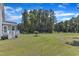 Spacious backyard with green grass, mature trees, and a swing set for outdoor enjoyment at 326 S Parliament Way, Clayton, NC 27520