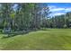 Large grassy backyard with mature trees, a swing, and ample space for recreation at 326 S Parliament Way, Clayton, NC 27520
