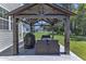 Relaxing covered deck featuring outdoor furniture, a grill, and views of the expansive backyard at 326 S Parliament Way, Clayton, NC 27520
