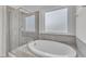 Bright bathroom featuring a tub and separate shower with glass door at 326 S Parliament Way, Clayton, NC 27520