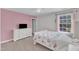 Bedroom featuring neutral carpet, a bed with floral bedding, and a window at 326 S Parliament Way, Clayton, NC 27520
