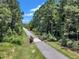 Scenic view of a paved community walking path surrounded by lush trees and greenery at 326 S Parliament Way, Clayton, NC 27520