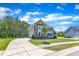 Well-manicured lawn with lovely two-story brick home and long driveway on a beautiful sunny day at 326 S Parliament Way, Clayton, NC 27520