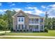 Charming two-story brick home featuring a welcoming porch, black shutters, and lush front yard at 326 S Parliament Way, Clayton, NC 27520