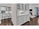 Kitchen features white cabinets, tile backsplash and marble counters with view into living room with fireplace at 326 S Parliament Way, Clayton, NC 27520