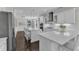 Gourmet kitchen features a large island with seating and stainless appliances with white cabinets and counters at 326 S Parliament Way, Clayton, NC 27520