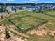 Aerial shot of a fenced community playground area surrounded by lush green grass at 326 S Parliament Way, Clayton, NC 27520