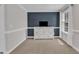 Inviting sitting room featuring blue accent wall, plush carpet, large windows, and lots of natural light at 326 S Parliament Way, Clayton, NC 27520