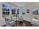 Bright sunroom boasts natural light with views of the outdoors, and cozy seating area with two chairs at 326 S Parliament Way, Clayton, NC 27520