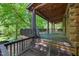Spacious wooden back porch providing a charming outdoor living area with tree-lined views at 3263 S Jim Minor Rd Rd, Haw River, NC 27258