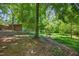View of the backyard with mature trees and a storage shed at 3263 S Jim Minor Rd Rd, Haw River, NC 27258
