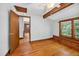 Bright bedroom featuring hardwood floors, exposed beams, and a log accent wall at 3263 S Jim Minor Rd Rd, Haw River, NC 27258