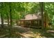 Cozy log cabin exterior surrounded by lush greenery and mature trees at 3263 S Jim Minor Rd Rd, Haw River, NC 27258