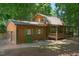 Log cabin features a covered front porch, attached garage, and lovely green shutters at 3263 S Jim Minor Rd Rd, Haw River, NC 27258