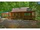 Charming log cabin with a covered front porch and green shutters at 3263 S Jim Minor Rd Rd, Haw River, NC 27258