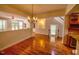 Open-concept dining room with hardwood floors, a modern chandelier, and a view into the living area at 332 Bridgegate Dr, Cary, NC 27519