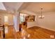 Dining area showcasing hardwood floors and open view into the kitchen with wooden cabinetry at 332 Bridgegate Dr, Cary, NC 27519