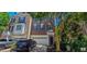 Three-story brick townhome featuring an attached two-car garage and mature landscaping at 332 Bridgegate Dr, Cary, NC 27519