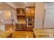 Bright kitchen with wooden cabinets, stainless double ovens, wine rack, beverage cooler, tile backsplash, and granite countertops at 332 Bridgegate Dr, Cary, NC 27519