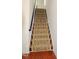 Carpeted staircase leading to the upper level of the house with hardwood flooring at the base at 332 Bridgegate Dr, Cary, NC 27519