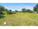 Vibrant green lawn with mature trees and garden beds under a clear blue sky at 3831 Abattoir Rd, Angier, NC 27501
