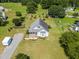 Aerial view of a charming home with a well-maintained lawn, mature trees, and a gravel driveway at 3831 Abattoir Rd, Angier, NC 27501