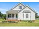 Charming home featuring white siding, a cozy front porch, and manicured landscaping at 3831 Abattoir Rd, Angier, NC 27501
