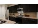A modern kitchen features stainless steel appliances, dark cabinets, and granite countertops for a sophisticated touch at 40 Digging Time Ave, Princeton, NC 27569
