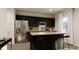 Kitchen boasts stainless steel appliances, dark cabinetry, and an island with barstool seating and a sink at 40 Digging Time Ave, Princeton, NC 27569