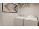 Neat laundry room with side-by-side washer and dryer, wall decor and shelf storage at 40 Digging Time Ave, Princeton, NC 27569
