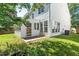A white house with a sunroom that connects to a manicured backyard lawn at 410 Willingham Rd, Morrisville, NC 27560