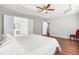 Bright bedroom showcasing a king bed, hardwood floors, and access to a bathroom at 410 Willingham Rd, Morrisville, NC 27560