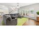 Bright living room with staircase, large gray sectional and verdant area rug at 410 Willingham Rd, Morrisville, NC 27560