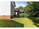 Side view of the house, showing the backyard, raised wooden deck, stairs and trees at 4505 Woodlawn Dr, Raleigh, NC 27616