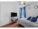 Bedroom with hardwood floors and dresser with mounted television at 4505 Woodlawn Dr, Raleigh, NC 27616