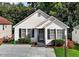 Charming single-story home featuring classic white siding, black shutters and mature landscaping at 4505 Woodlawn Dr, Raleigh, NC 27616