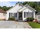 Charming home features a front entrance, black shutters, and lush landscaping at 4505 Woodlawn Dr, Raleigh, NC 27616