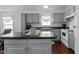 This kitchen boasts gray cabinets, an island, and an eat-in dining area at 4505 Woodlawn Dr, Raleigh, NC 27616